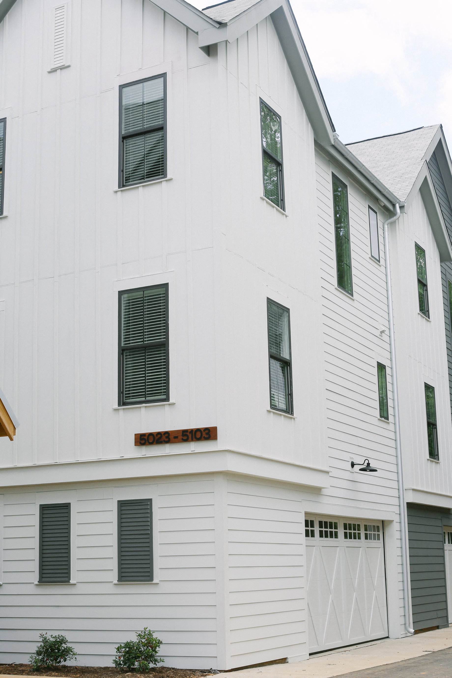 the side of a white building with a garage door