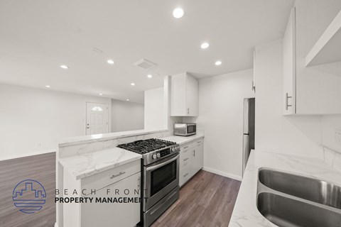 A modern kitchen with a stove top oven and a sink.