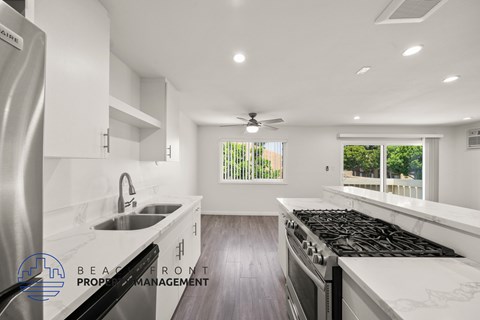 A modern kitchen with stainless steel appliances and white cabinetry.