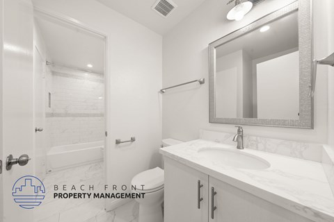 A bathroom with a white sink and a mirror.