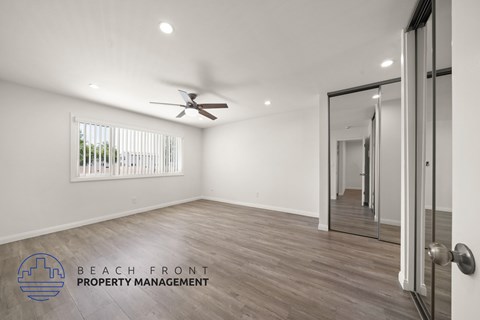 A room with a ceiling fan and a door leading to another room.