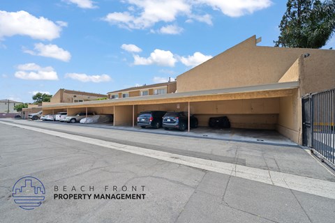 A parking lot with a building and cars parked in front of it.