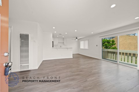 A spacious room with wooden flooring and a ceiling fan is available for rent.