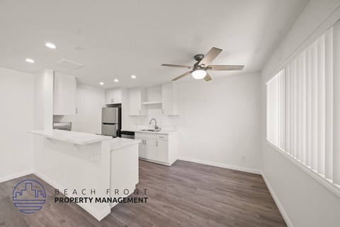 A spacious room with a ceiling fan and a logo for Beach Front Property Management.