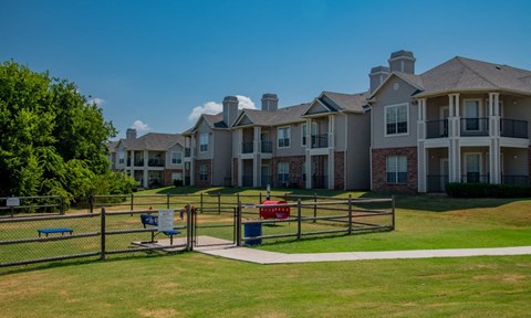 A large, well-maintained apartment complex with a playground in the foreground.