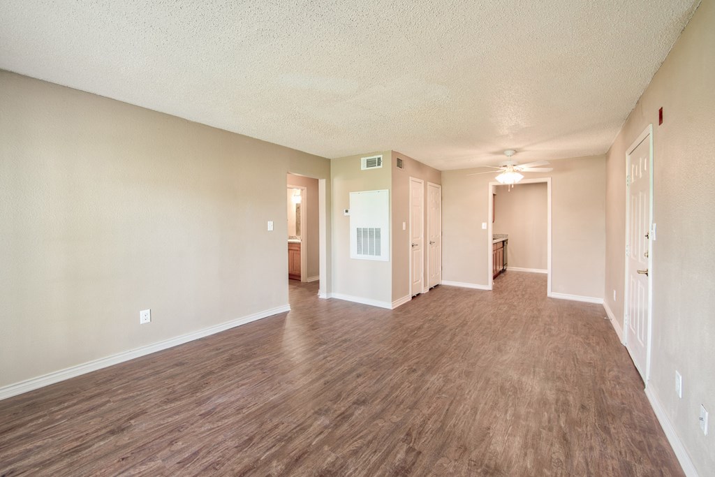 the spacious living room and dining room of an empty apartment