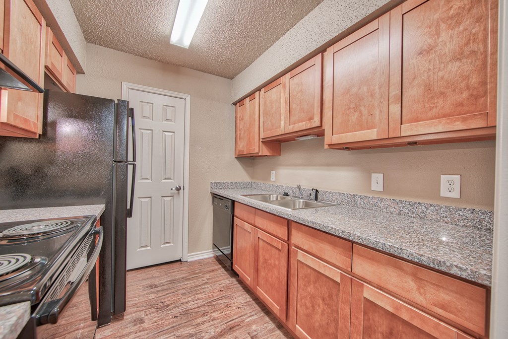 a kitchen with wooden cabinets and a sink and a refrigerator