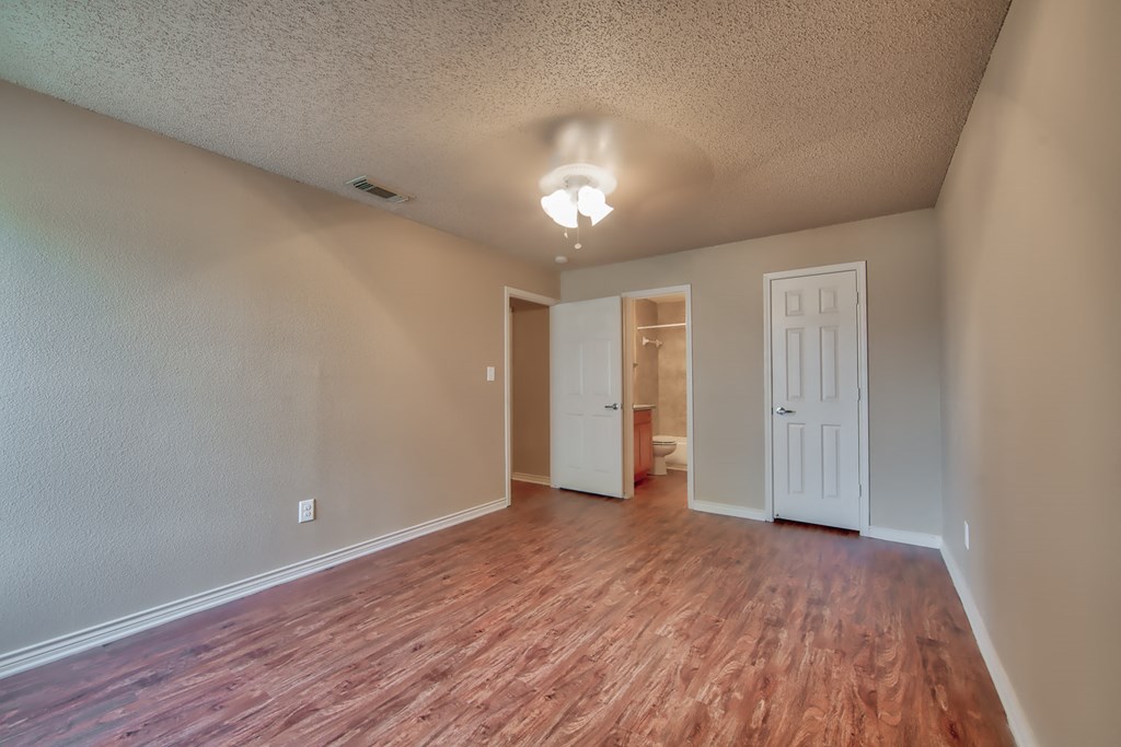 a living room with a hard wood floor and a white door