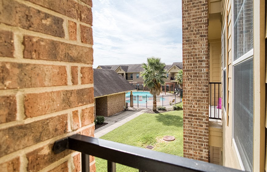 the view of a swimming pool from the balcony of a house