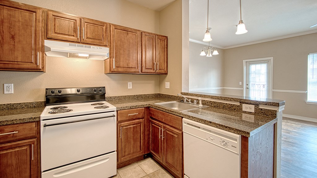 an empty kitchen with wooden cabinets and white appliances