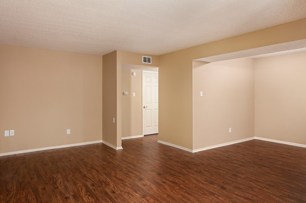 an empty living room with a hardwood floor