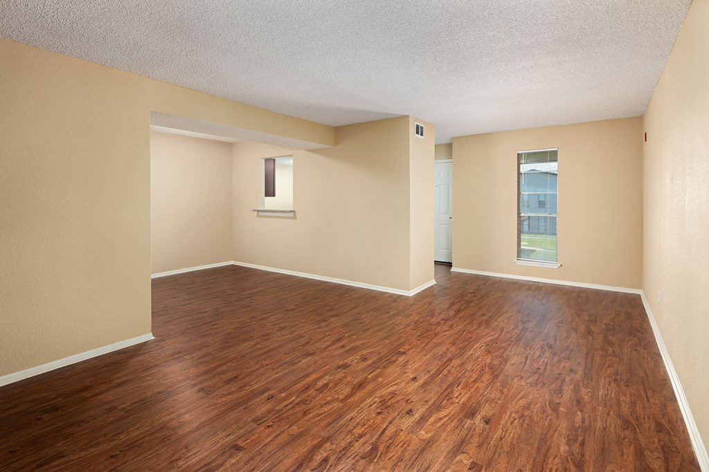 a living room with hardwood floors and beige walls