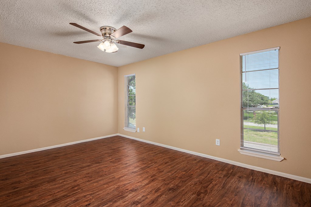 a bedroom with hardwood floors and a ceiling fan