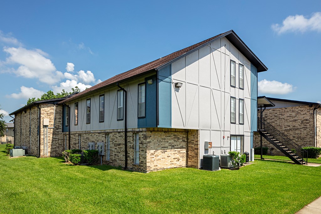 an image of the front of a building with a green lawn in front of it