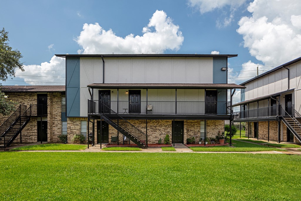 an exterior view of a building with a green lawn in front of it