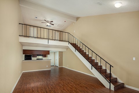 the view of a living room with a staircase in the corner