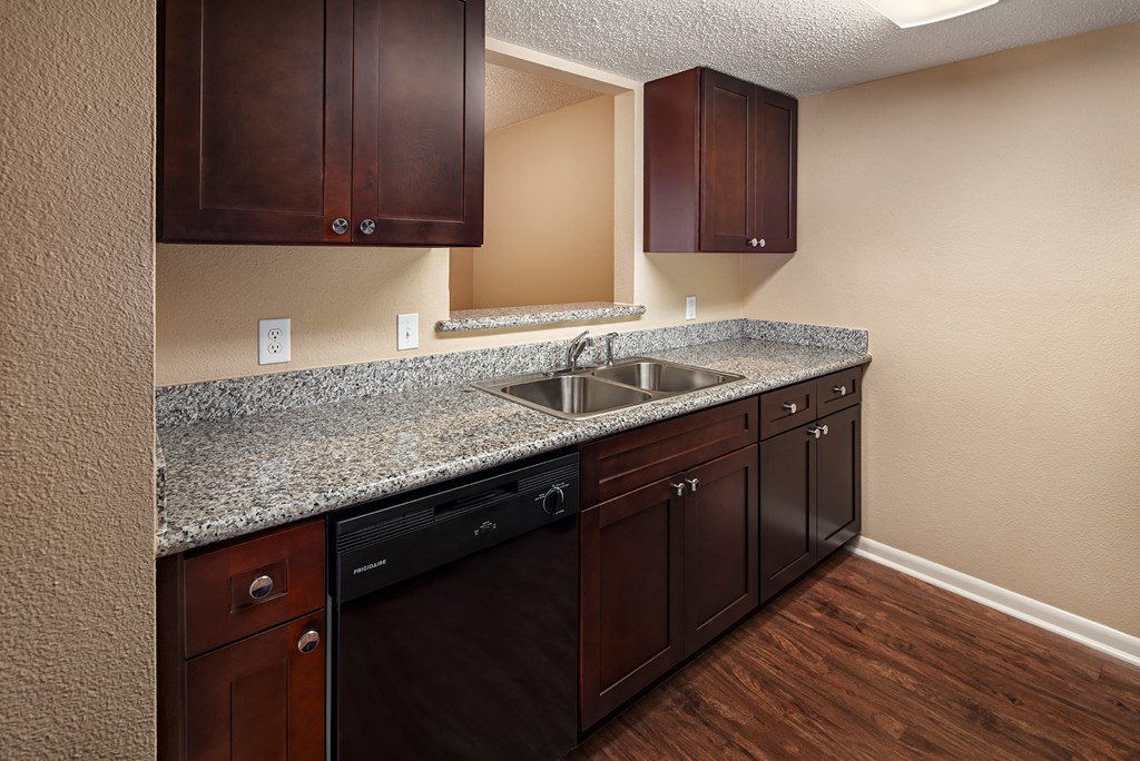 a kitchen with dark wood cabinets and granite countertops