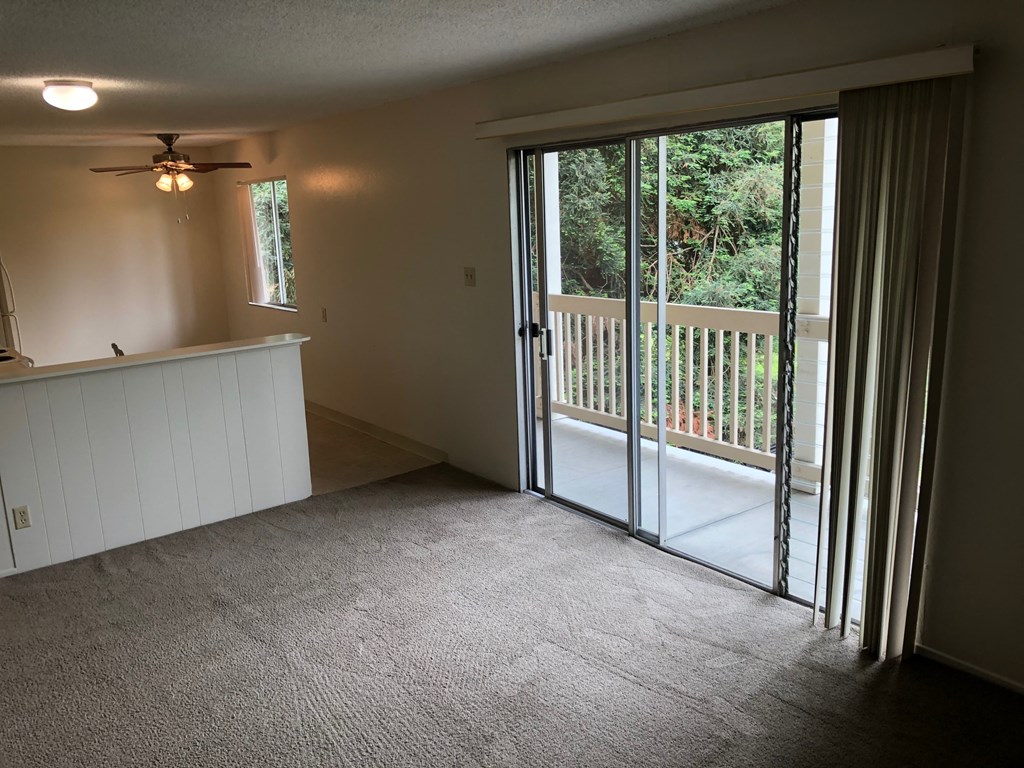 a living room with a balcony and sliding glass doors