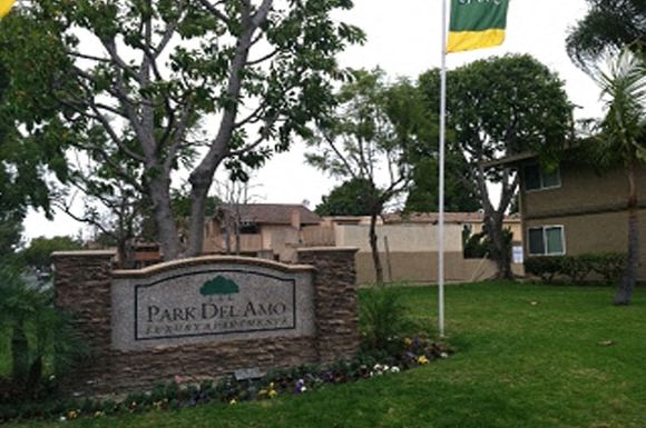 A sign that says Park Del Amo in front of a building.