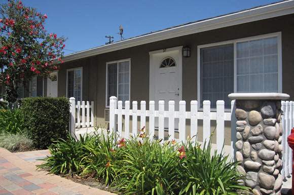 A house with a white picket fence and a red mailbox.