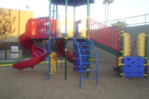 A playground with a red slide and a blue slide.