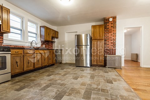 a kitchen with a stainless steel refrigerator and wooden cabinets