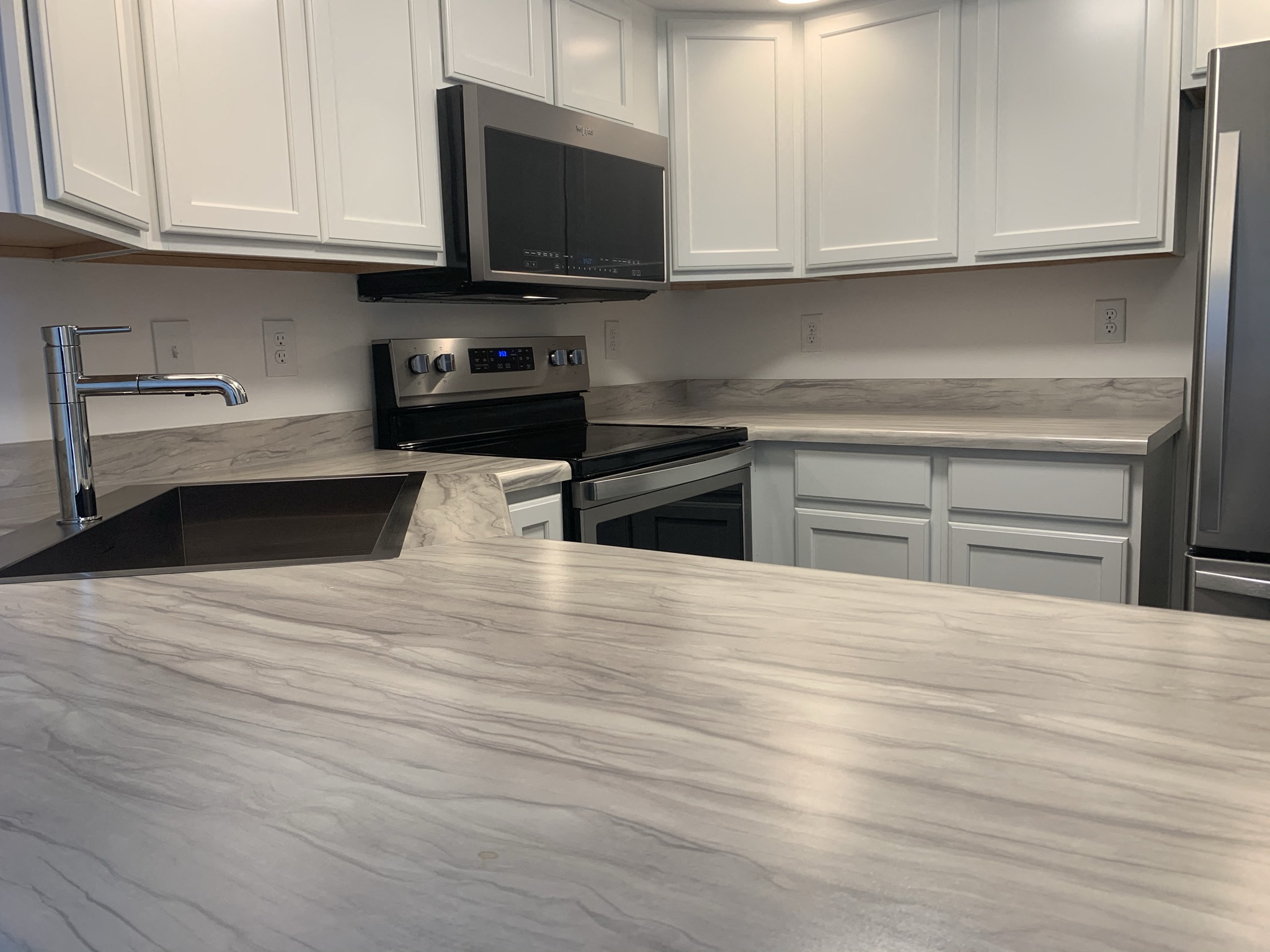 a kitchen with white cabinets and a counter top
