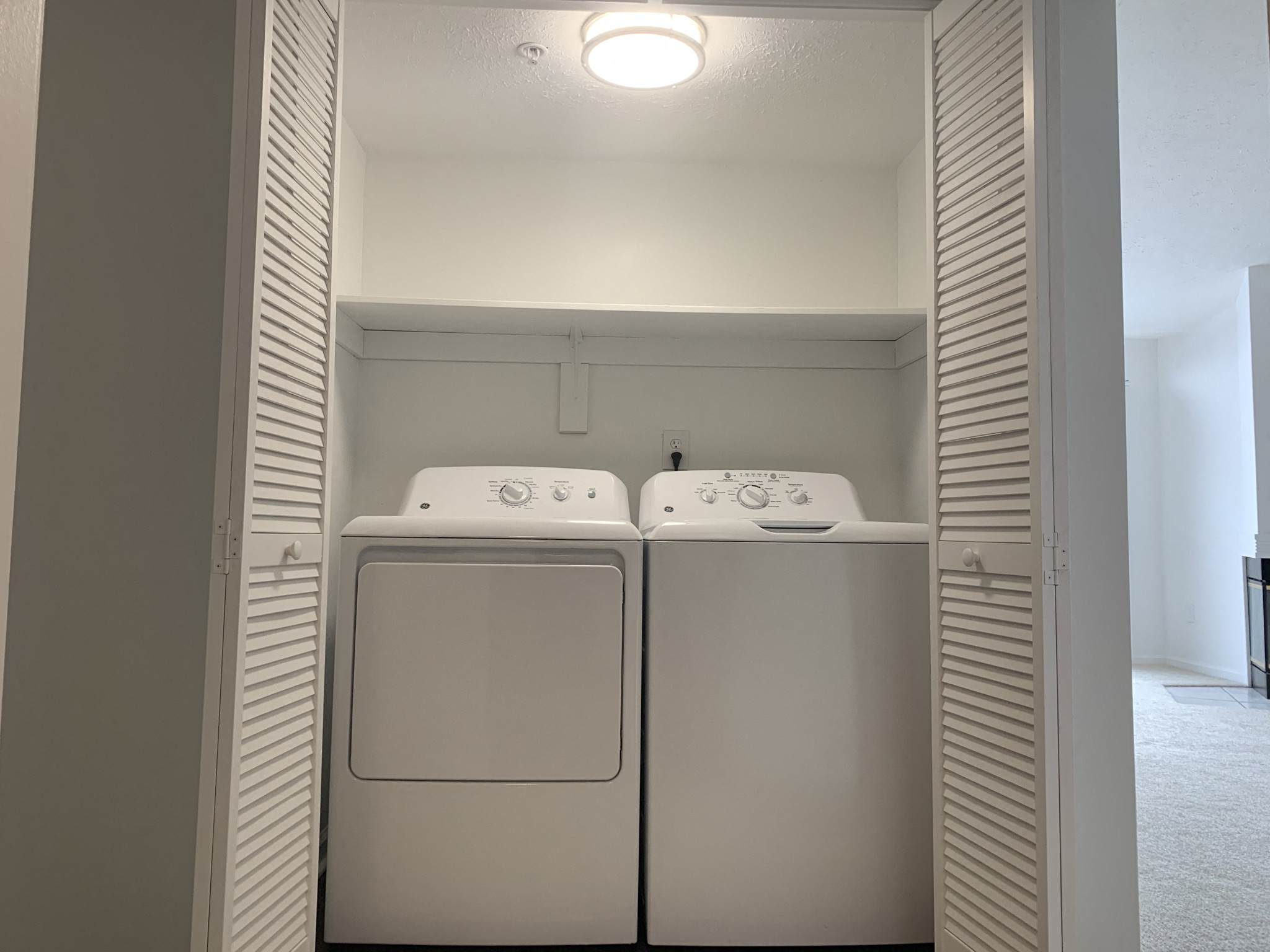 an empty laundry room with a washer and dryer in it