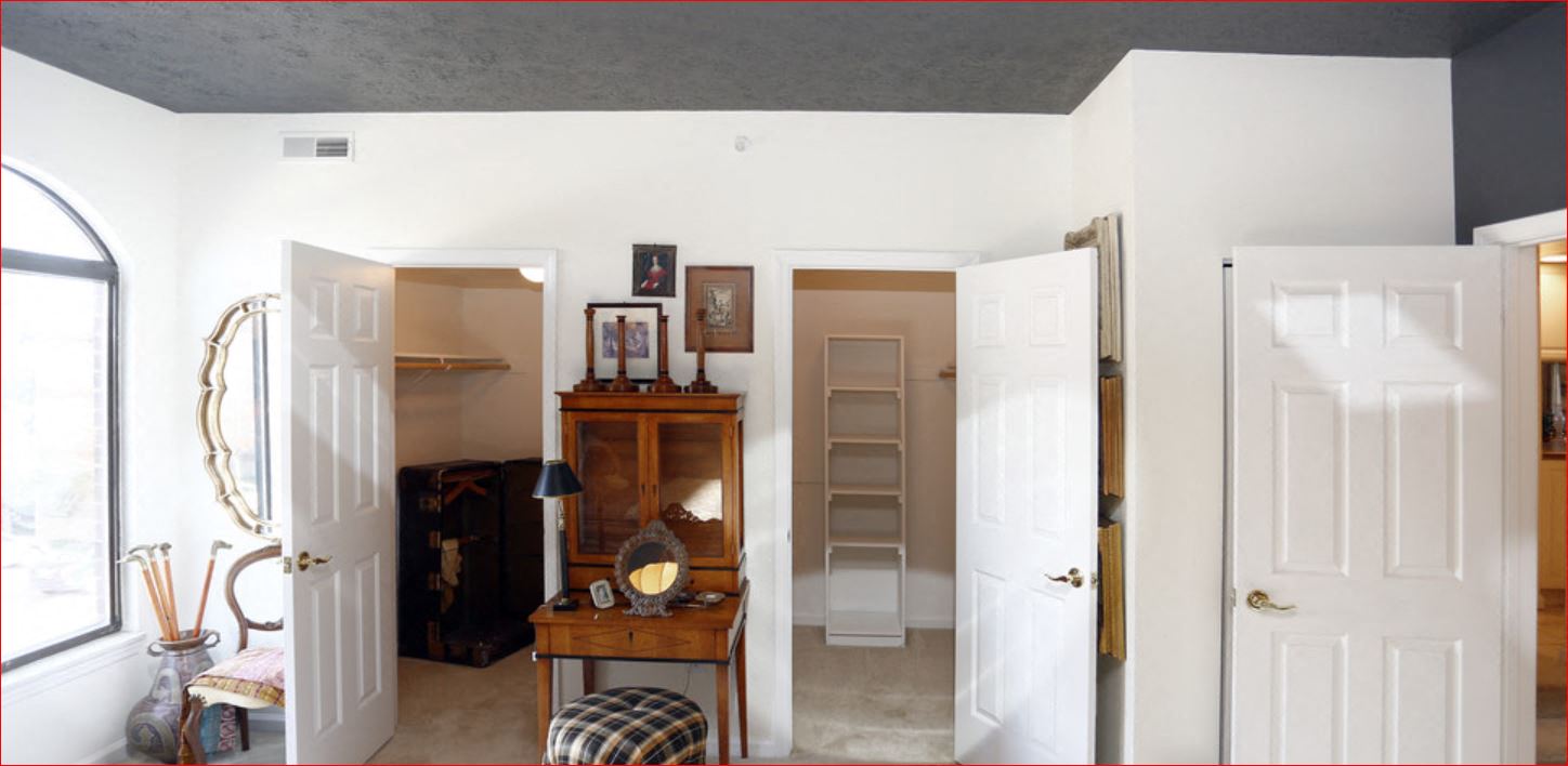 a living room with four doors open and a staircase in the background
