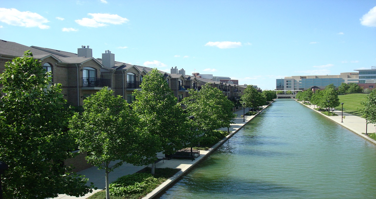 a river running through a city with houses and trees