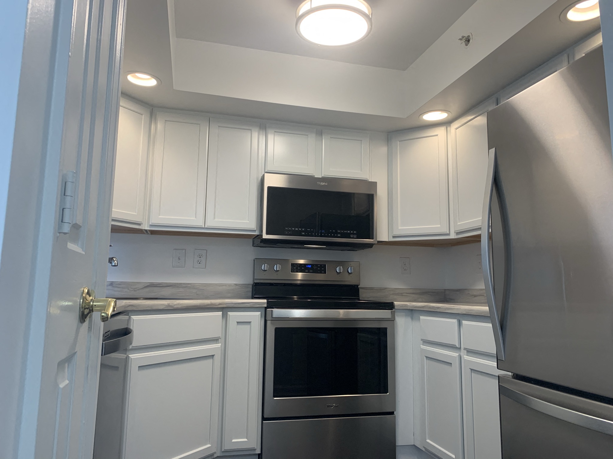 a kitchen with white cabinets and stainless steel appliances