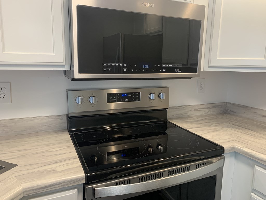 a kitchen with a stove and a tv above it