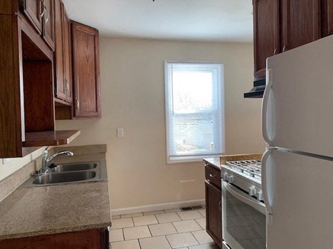A kitchen with a sink, stove, and refrigerator.