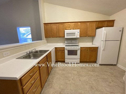 a small kitchen with white appliances and wooden cabinets