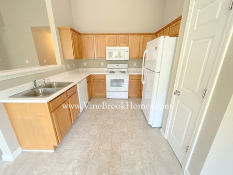 A kitchen with wooden cabinets and a white refrigerator.