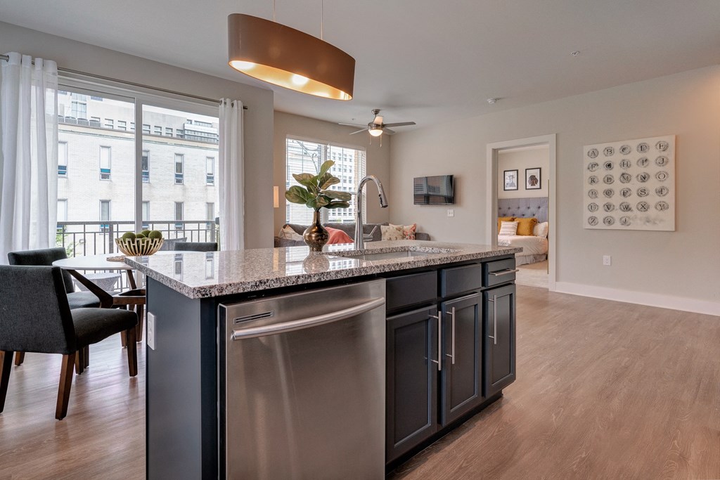 an open kitchen and living room with an island and a large window