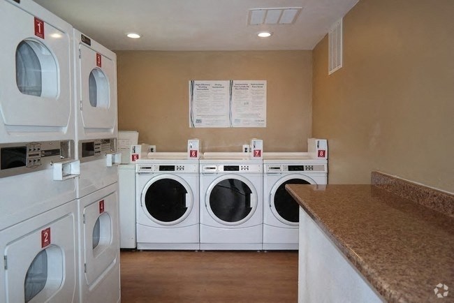 a washer and dryer laundry room with four washing machines