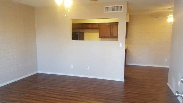an empty living room with white walls and wood floors