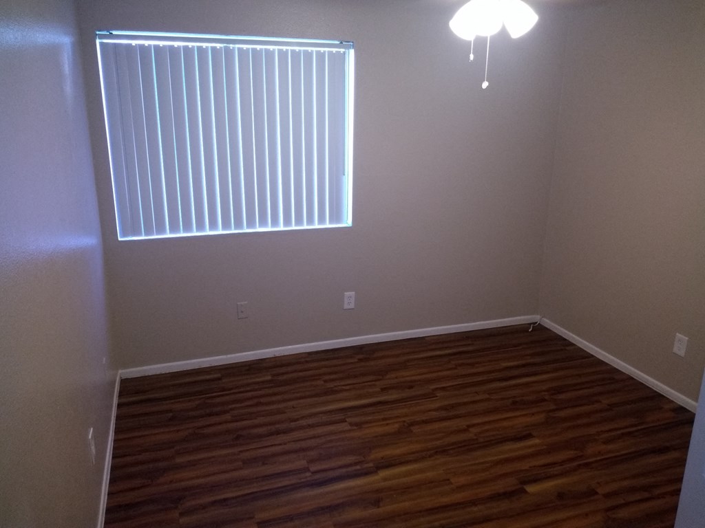 a empty room with wood floors and a window