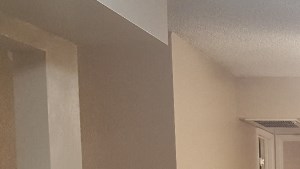 an empty kitchen with a white door and a ceiling fan