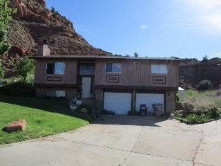 a brown house with a mountain in the background