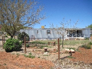 a house with a yard and a fence in front of it