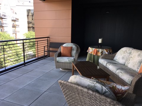 a living room with chairs and a table on a balcony