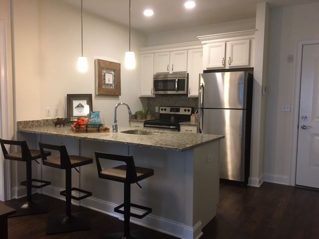 a kitchen with a granite counter top and stainless steel refrigerator