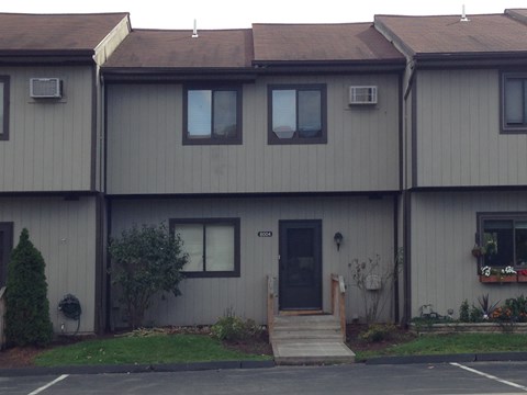 A grey building with a black door and windows.