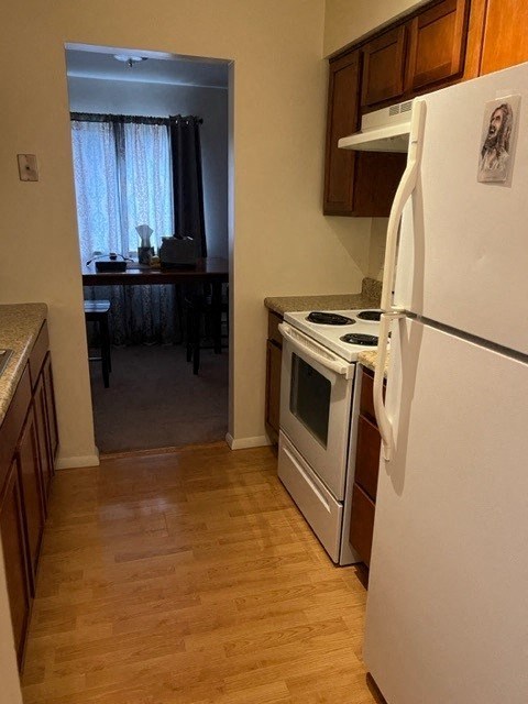 A kitchen with a white fridge and a white oven.