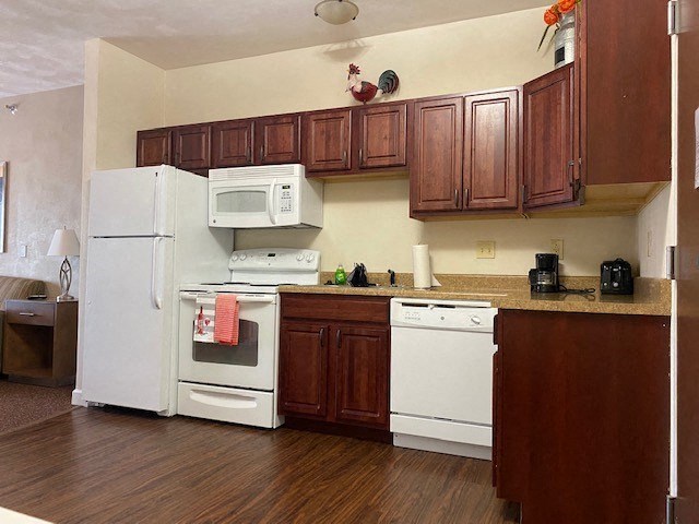 a kitchen with white appliances and wooden cabinets