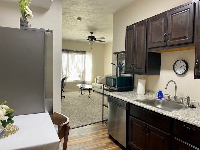 a kitchen and living room with a refrigerator and a sink