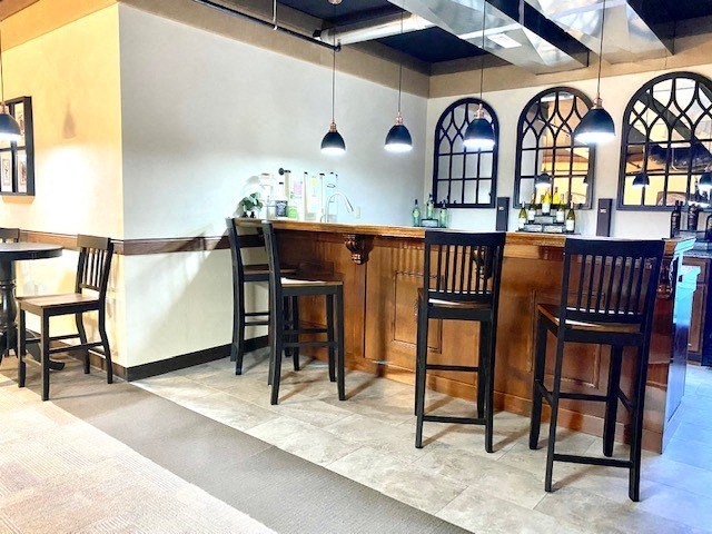 a bar in a restaurant with tables and chairs