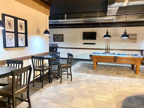 a game room with a pool table and tables